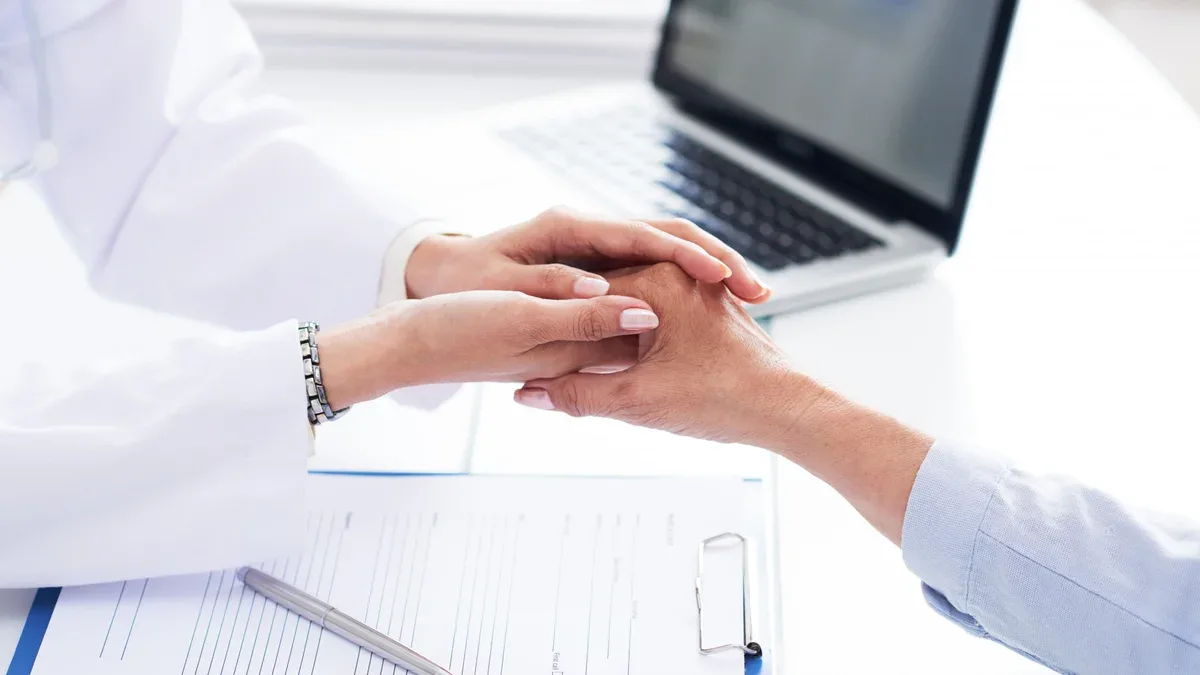 Recadrées des mains du docteur réconfortant patient méconnaissable