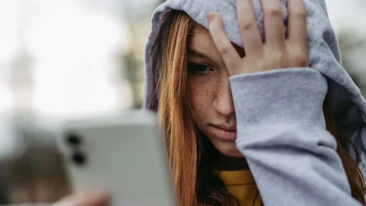 Portrait d'une adolescente qui regarde son smartphone triste anxieuse seule Cyberbullying Une fille est harcelée menacée en ligne
