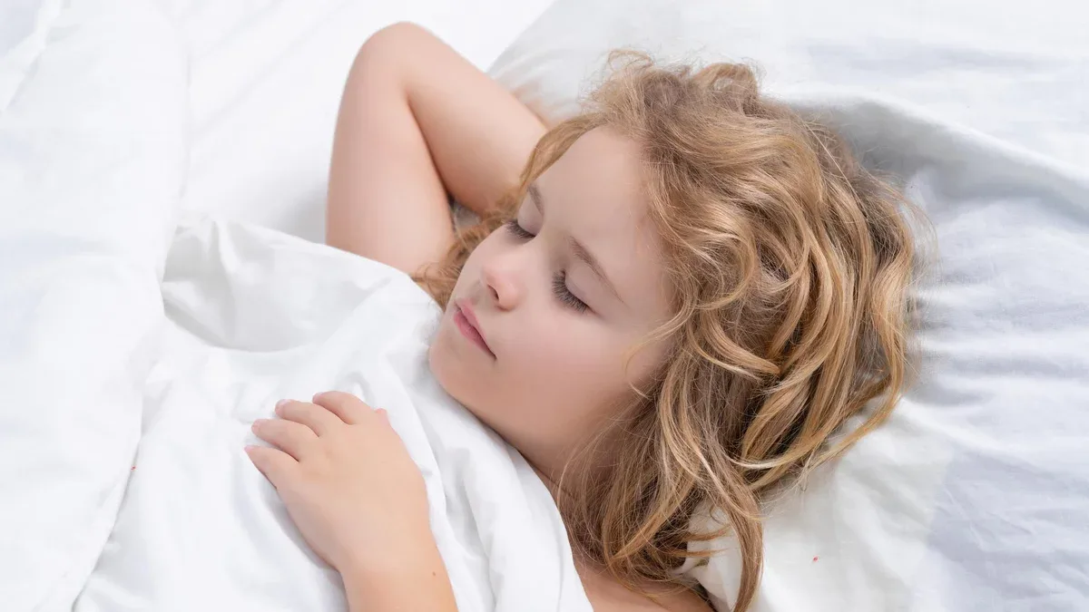 L'enfant dort dans un lit blanc confortable L'enfant adorable dort dans le lit L'enfant endormi