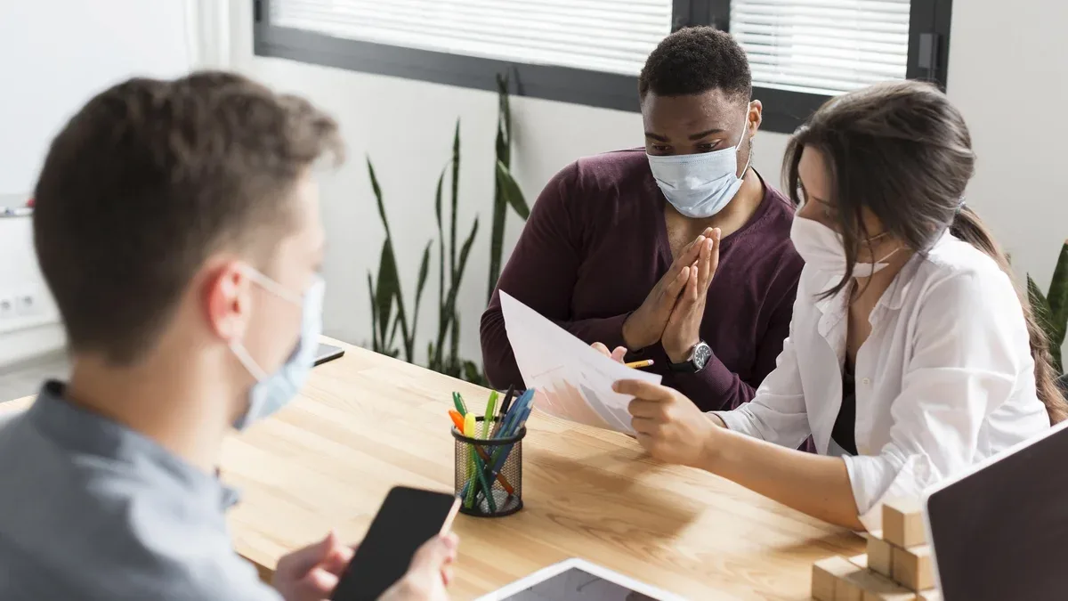 Les personnes travaillant au bureau pendant la pandémie avec des masques sur