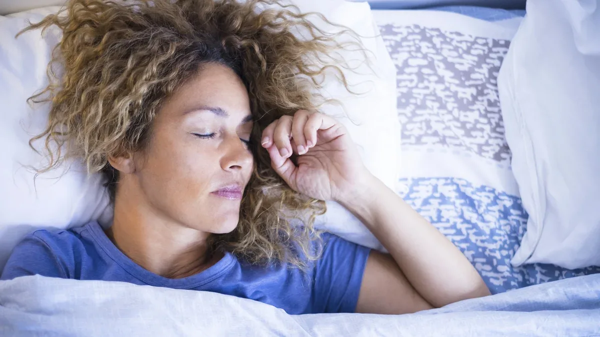 Concept de détente et de sommeil avec une belle femme caucasienne dormant dans la lumière du matin à la maison ou à l'hôtel