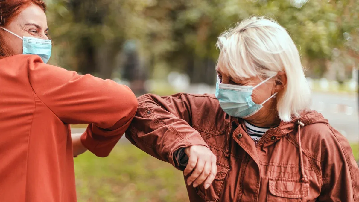 Coup de coude Deux personnes se cognent les coudes pour éviter le coronavirus à l'extérieur.