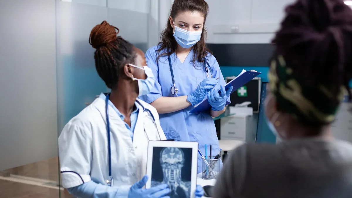 Le médecin discute des résultats du diagnostic de la lésion de la colonne vertébrale cervicale du patient et du traitement avec l'infirmière lors du rendez-vous médical. Examen médical de radiologie dans un environnement clinique antibactérien stérile