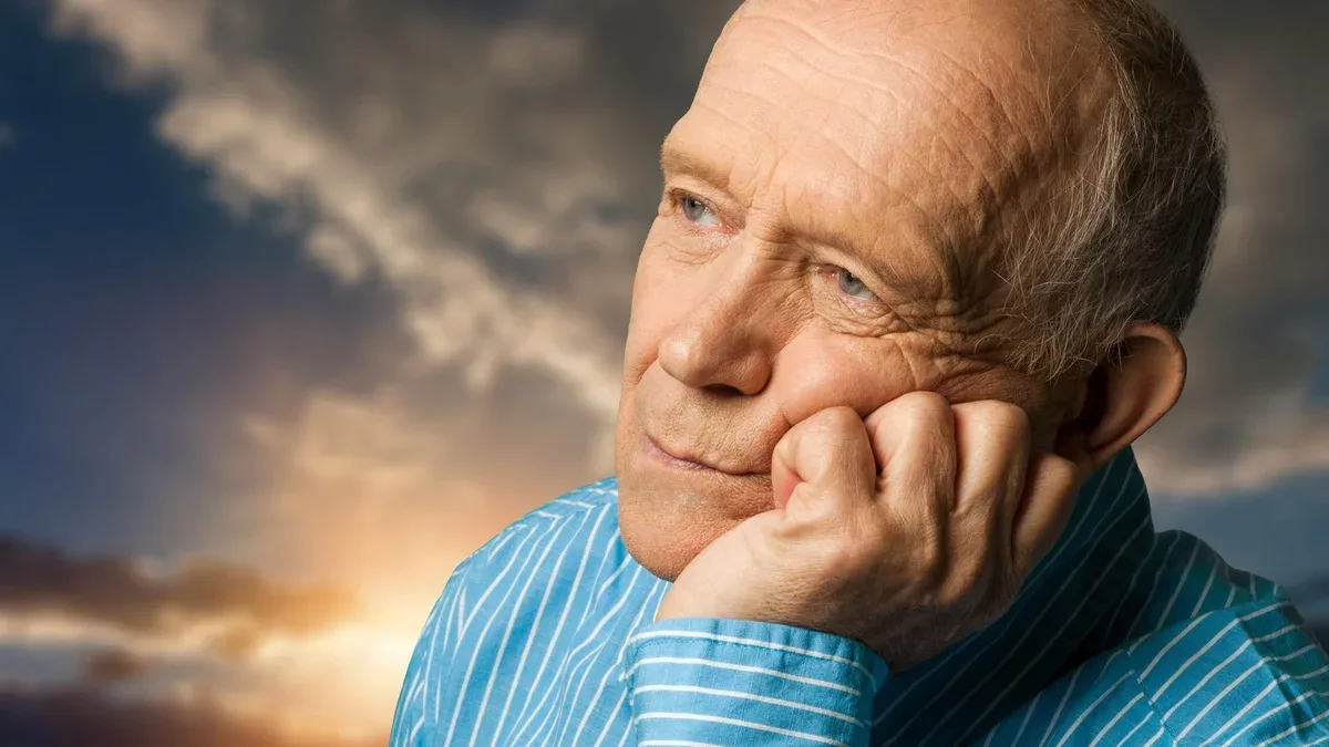 L'homme plus âgé est triste sur le fond de ciel