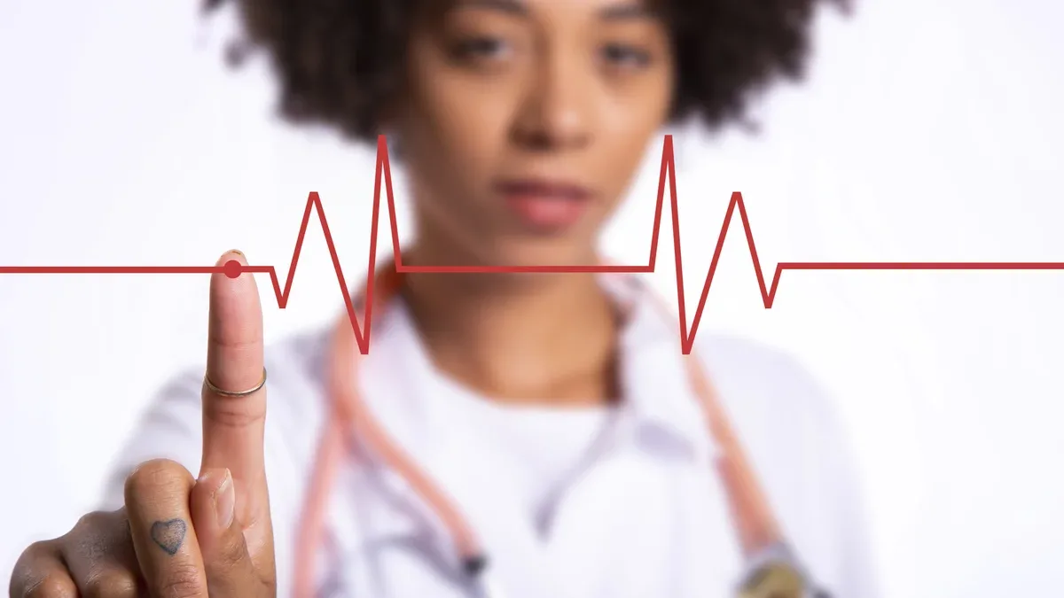 Jeune femme médecin dessin cardiogramme du rythme cardiaque dans l'air sur fond blanc