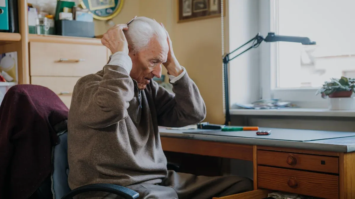 Toute la longueur de l'homme assis sur la table à la maison