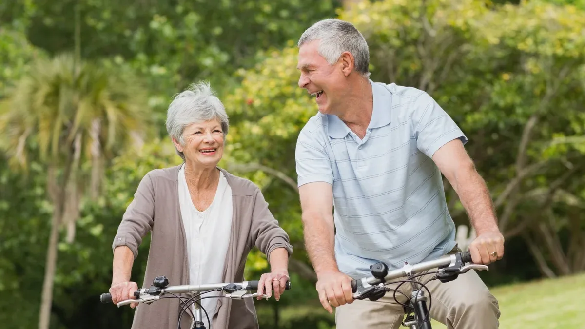 Couple de personnes âgées gaies à vélo dans la campagne