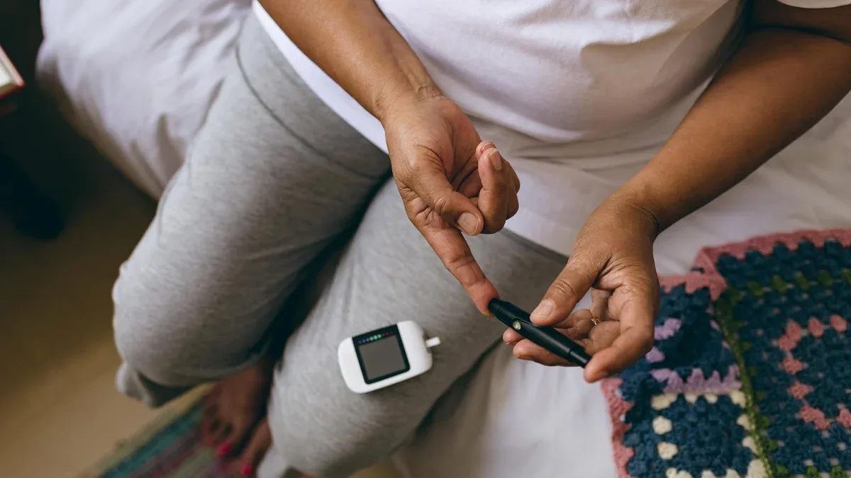 Patiente âgée vérifiant le taux de sucre dans le sang avec un glucomètre