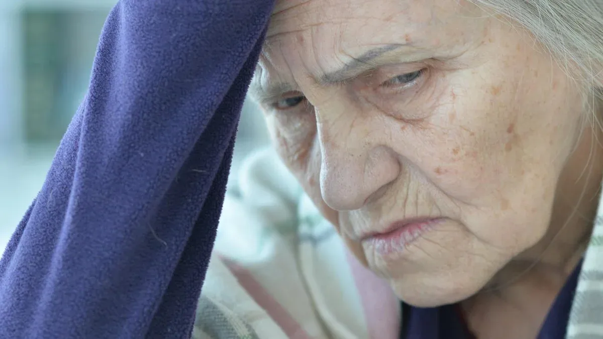 Triste femme âgée assise à table