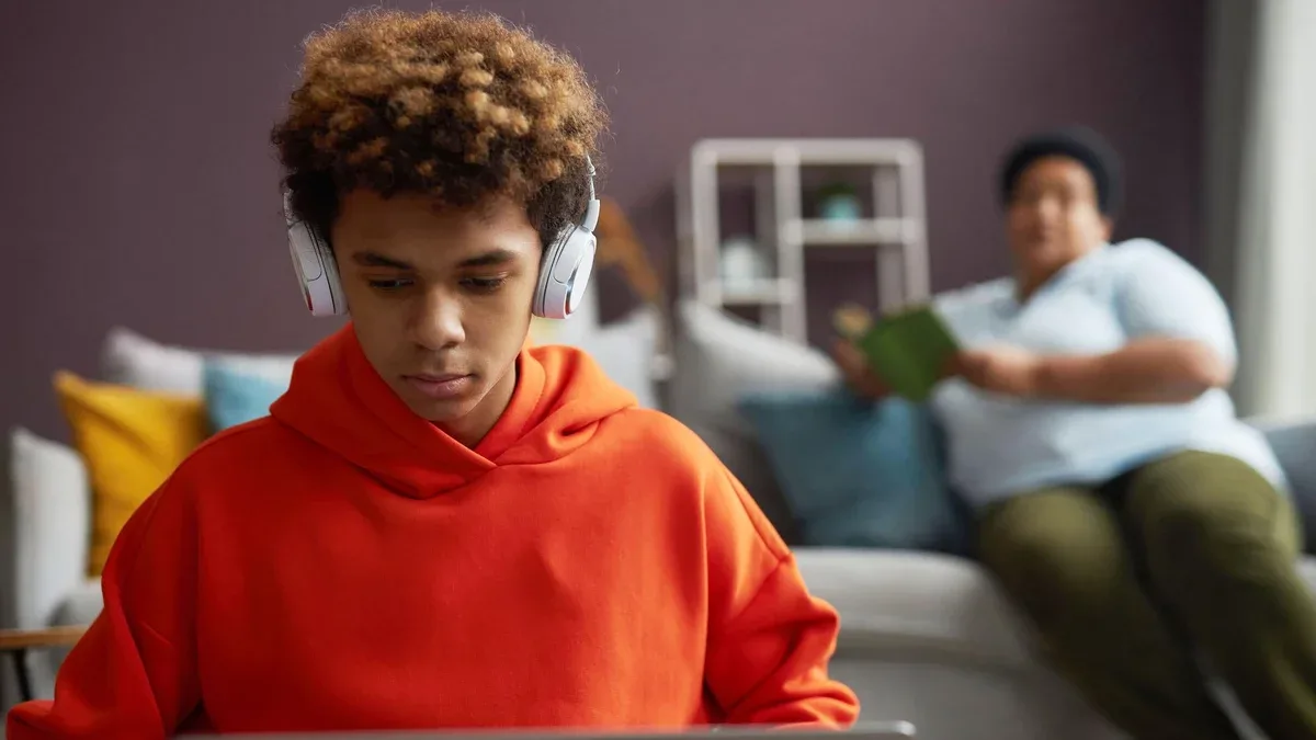 Concentrez-vous sur un écolier diligent dans un casque et un sweat à capuche rouge