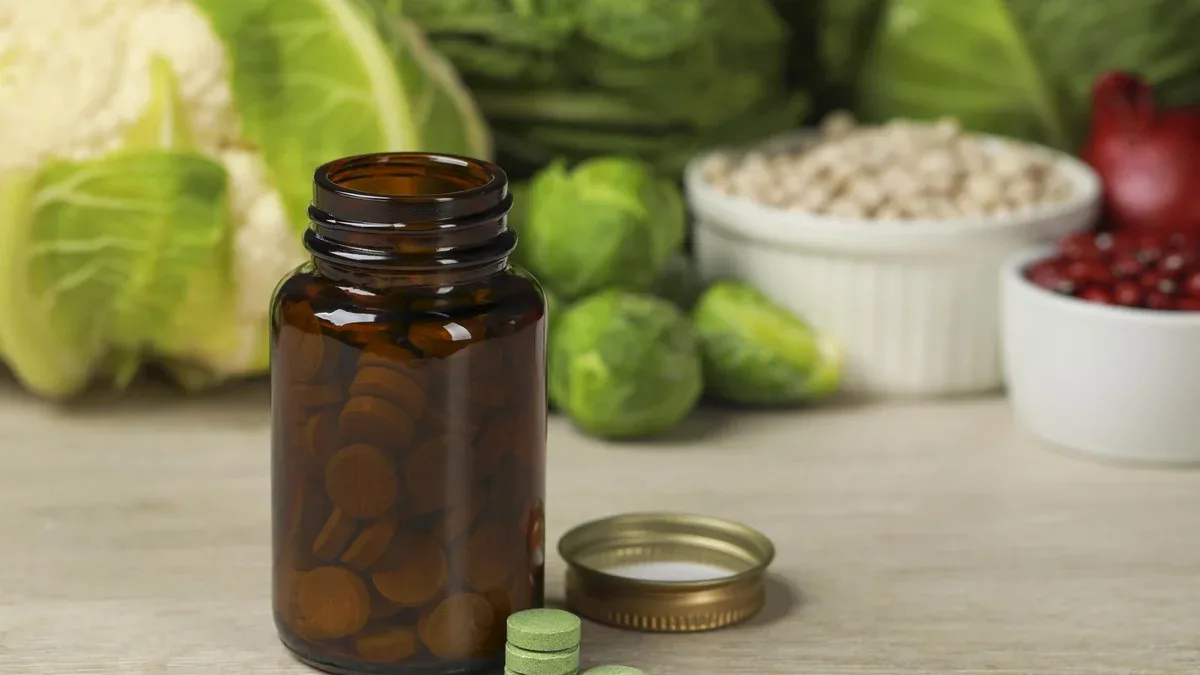 Bouteille de pilules et de denrées alimentaires sur une table en bois blanc Suppléments prébiotiques