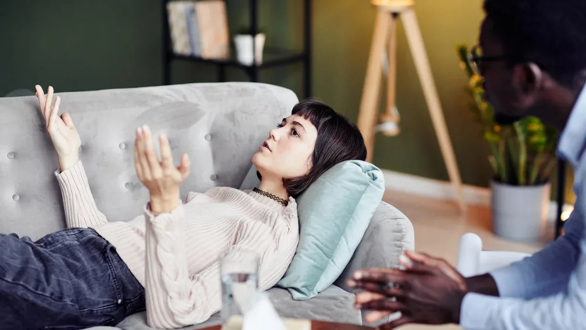 Jeune femme partageant des difficultés lors d'une séance de thérapie privée avec un psychologue