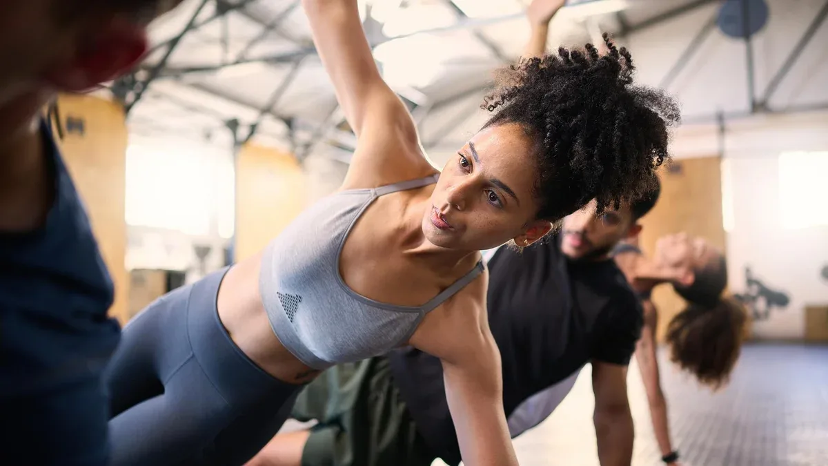 Remise en forme des amis actifs et en bonne santé qui s'étirent en faisant de l'exercice ou de l'entraînement cardio ensemble dans la salle de sport