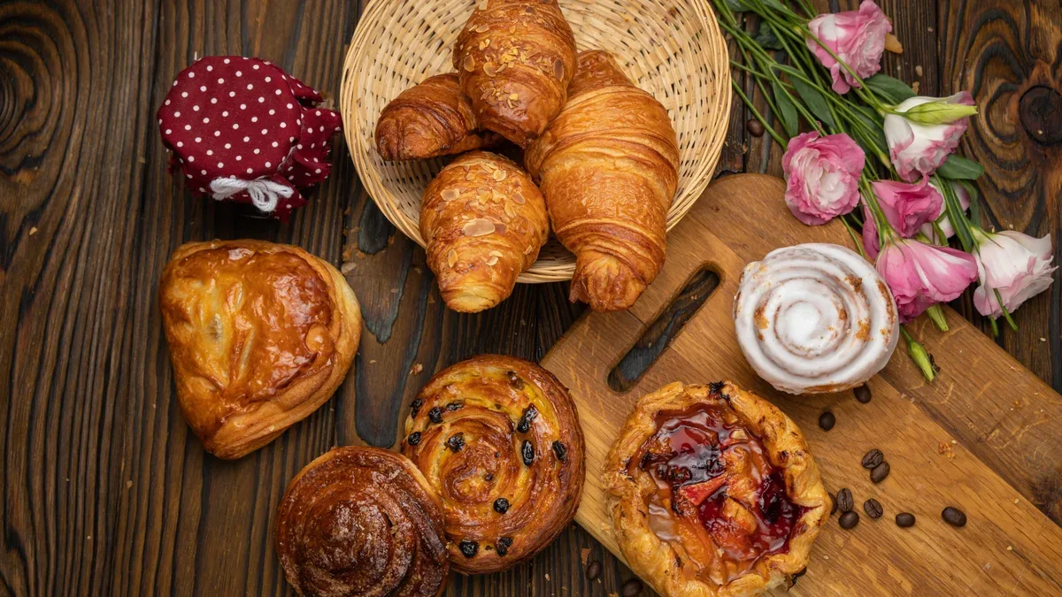 Pains croissants pâtisseries assorties sur une table en bois brun