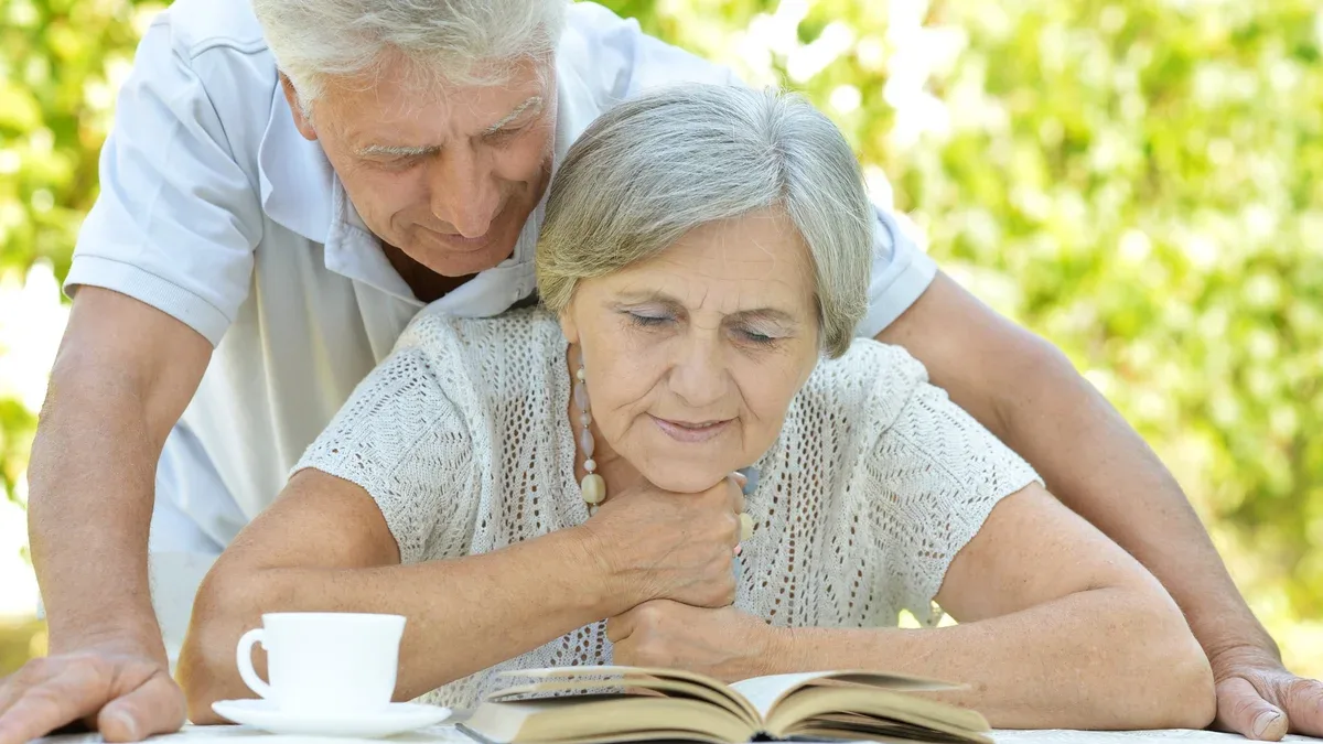 Beau couple de personnes âgées assis à table en été