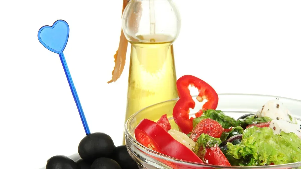 Salade grecque fraîche dans un bol en verre isolé sur blanc