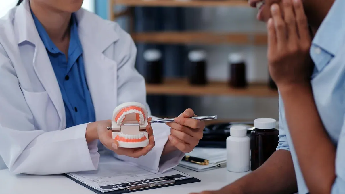 Consultation dentaire visite du patient au bureau de la clinique dentaire Dentiste portant des prothèses dentaires pour expliquer les dents Recommander des lignes directrices pour l'orthodontie Dentiste donnant des conseils sur l'état des patients
